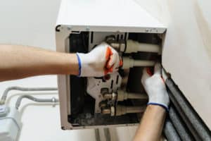 heating engineer installing a boiler in a home