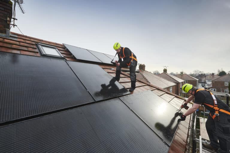 solar panel installers on residential roof